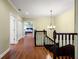 Upstairs hallway with hardwood floors, chandelier, white trim and multiple bedrooms creates a harmonious and inviting space at 11602 Innfields Dr, Odessa, FL 33556