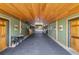 Interior hallway view of a horse stable, with doors to stalls on either side and a rubber brick floor at 11602 Innfields Dr, Odessa, FL 33556