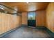 Clean horse stall featuring wood paneling, a metal door, and a window with an exterior view at 11602 Innfields Dr, Odessa, FL 33556