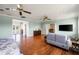 Bright main bedroom with hardwood floors, ceiling fans, and adjacent balcony access creates a relaxing retreat at 11602 Innfields Dr, Odessa, FL 33556