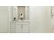 Bright bathroom features a vanity, mirror, and ample cabinet space for storage at 11738 Brae Way, Dade City, FL 33525