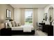 Bedroom featuring a window view, black accents, desk area, and a full-length mirror at 11738 Brae Way, Dade City, FL 33525