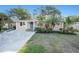 Inviting home featuring a well-kept lawn, mature trees, and a welcoming front entrance at 1513 Owen Dr, Clearwater, FL 33759