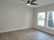 Bright bedroom with wood-look floors, two windows, neutral walls, and a modern ceiling fan at 1537 Palmetto St, Clearwater, FL 33755
