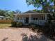 Charming bungalow featuring a covered front porch with columns, a brick walkway, and verdant landscaping at 1537 Palmetto St, Clearwater, FL 33755