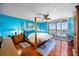 The bedroom has a four-poster bed, blue walls, wood floors, and a balcony at 1600 Gulf Blvd # 618, Clearwater, FL 33767