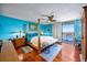The bedroom has a four-poster bed, blue walls, wood floors, and a balcony at 1600 Gulf Blvd # 618, Clearwater, FL 33767