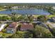 Aerial view showcases the home near a serene lake, surrounded by lush trees and landscaping at 1608 Ledgestone Dr, Brandon, FL 33511