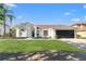 Well-maintained white home with a lush green lawn, black garage doors, and manicured landscaping at 1608 Ledgestone Dr, Brandon, FL 33511