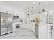 Modern kitchen features stainless appliances, white cabinets, and marble floors, illuminated by pendant lighting at 1608 Ledgestone Dr, Brandon, FL 33511