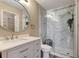 Updated bathroom showcasing a vanity with a framed mirror and a glass enclosed shower with tile and greenery at 18228 Paradise Point Dr, Tampa, FL 33647