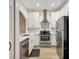 Well-lit kitchen featuring stainless steel appliances, white cabinetry, and wood flooring at 18228 Paradise Point Dr, Tampa, FL 33647