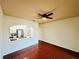 Bright living room with an arched kitchen view, wood floors, and a ceiling fan at 18228 Paradise Point Dr, Tampa, FL 33647
