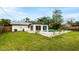 Home's backyard featuring an in-ground pool, white rock landscaping and green lawn at 1886 San Mateo Dr, Dunedin, FL 34698