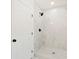 Bathroom featuring a glass-enclosed shower with a rainfall shower head and marble tiling at 1886 San Mateo Dr, Dunedin, FL 34698