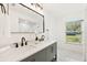 Stylish bathroom featuring a double sink vanity, herringbone cabinets, and marble floors at 1886 San Mateo Dr, Dunedin, FL 34698