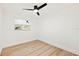 Clean bedroom with wood-look flooring, a ceiling fan, and a bright window for natural light at 1886 San Mateo Dr, Dunedin, FL 34698