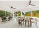 Bright dining area featuring a modern table setting, stylish chairs, and scenic views of the outdoor pool and backyard at 1886 San Mateo Dr, Dunedin, FL 34698