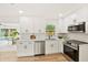 Well-lit kitchen boasting white cabinetry, stainless steel appliances, and a convenient layout adjoining the dining area at 1886 San Mateo Dr, Dunedin, FL 34698