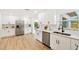 Updated kitchen with white cabinets and stainless steel appliances, offering views into the dining area and backyard at 1886 San Mateo Dr, Dunedin, FL 34698