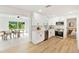 Bright, renovated kitchen featuring stainless steel appliances, white cabinets, and seamless flow to the dining area and bedroom at 1886 San Mateo Dr, Dunedin, FL 34698