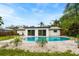 Backyard featuring a modern pool, white gravel, and minimal landscaping at 1886 San Mateo Dr, Dunedin, FL 34698
