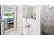 Elegant bathroom featuring marble tile shower, vanity, and view into the main bedroom at 19629 Fort King Run, Brooksville, FL 34601