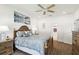 A well-lit bedroom features a wood bed frame, side tables, artwork and an ensuite bathroom at 19629 Fort King Run, Brooksville, FL 34601