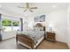 Cozy bedroom with a wooden bed frame, hardwood floors, and natural light from a large window at 19629 Fort King Run, Brooksville, FL 34601