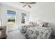 Sunlit bedroom with two beds, ceiling fan, and two large windows at 19629 Fort King Run, Brooksville, FL 34601