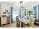 This dining room features a modern light fixture, decor, and bright windows with blue curtains at 19629 Fort King Run, Brooksville, FL 34601