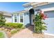 Charming blue home with a well-maintained walkway, vibrant flowers, and lush landscaping, exuding curb appeal at 19629 Fort King Run, Brooksville, FL 34601