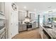 A stylish kitchen boasts gray cabinets, stainless steel appliances, granite countertops, and wood flooring at 19629 Fort King Run, Brooksville, FL 34601