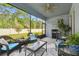 Inviting screened-in patio with comfortable seating, a grill, and serene views of the lush backyard at 19629 Fort King Run, Brooksville, FL 34601