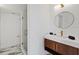 Bathroom showcasing a floating vanity, round mirror, and glass shower at 1979 E Skyline Dr, Clearwater, FL 33763