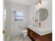 Bathroom featuring gold fixtures, marble-look countertop, and a round mirror at 1979 E Skyline Dr, Clearwater, FL 33763