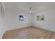 Bright bedroom with wood-look flooring, neutral walls, and ample natural light from two windows at 1979 E Skyline Dr, Clearwater, FL 33763