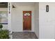 Elegant front door with decorative details, white brick siding, and well-kept landscaping at 1979 E Skyline Dr, Clearwater, FL 33763
