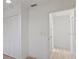 Hallway with white walls, closet with folding doors, and an entrance to another room at 1979 E Skyline Dr, Clearwater, FL 33763