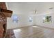 Sunlit living room with three windows and a cozy brick fireplace at 1979 E Skyline Dr, Clearwater, FL 33763