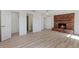 Bright living room featuring wood-look floors and a charming brick fireplace at 1979 E Skyline Dr, Clearwater, FL 33763