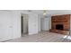 Bright living room with white walls, light wood flooring, a brick fireplace, and multiple doorways at 1979 E Skyline Dr, Clearwater, FL 33763