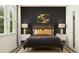 Modern bedroom with a striking dark accent wall, natural wood headboard, and plush bedding, creating a serene retreat at 22075 Storybook Cabin Way, Land O Lakes, FL 34637
