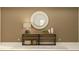 Tan hallway featuring a decorative mirror above a wooden console table with decorative vases and a lamp at 22075 Storybook Cabin Way, Land O Lakes, FL 34637