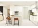 Open kitchen with white cabinets, stainless steel appliances, a center island with counter seating, and modern finishes at 22075 Storybook Cabin Way, Land O Lakes, FL 34637