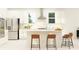 Bright kitchen with white cabinets, stainless steel appliances, and a center island with seating and modern lighting at 22075 Storybook Cabin Way, Land O Lakes, FL 34637
