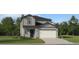 Charming two-story home with gray siding, a two-car garage, and a well-manicured front lawn at 2269 Blue Grosbeak Pl, Wimauma, FL 33598