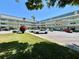 A view of the condo complex shows a well-maintained lawn, ample parking, and a light yellow exterior paint at 2459 Columbia Dr # 17, Clearwater, FL 33763