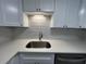 Bright kitchen with white cabinets, stainless steel sink, modern countertops and backsplash, offering a clean and functional space at 2459 Columbia Dr # 17, Clearwater, FL 33763