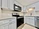 A close up view of the updated kitchen features modern stainless steel appliances and white cabinets at 2459 Columbia Dr # 17, Clearwater, FL 33763